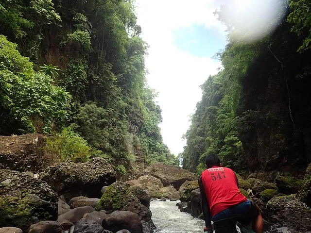 Batelier naviguant dans une gorge fluviale étroite et rocheuse