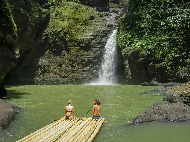 Deux personnes assises sur un radeau en bambou face aux chutes de Pagsanjan