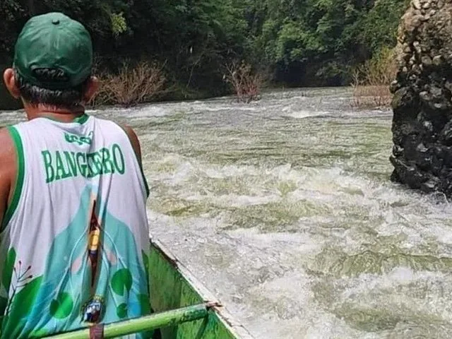 Boatman navigating rushing river rapids on the way to Pagsanjan Falls